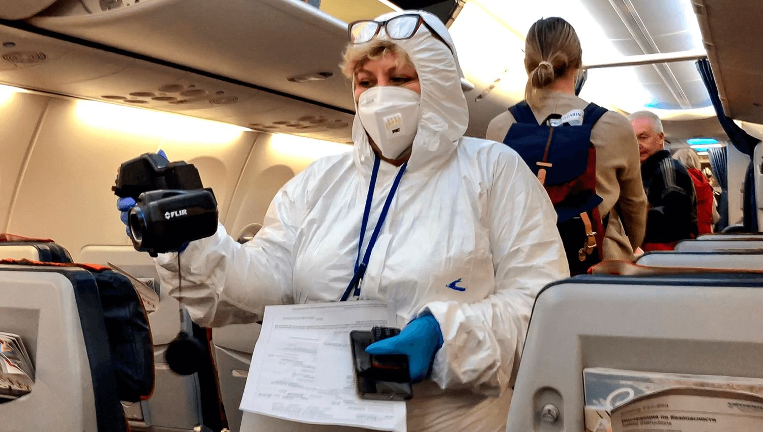 Control sanitario en el interior de un avión recién arribado a Ezeiza.