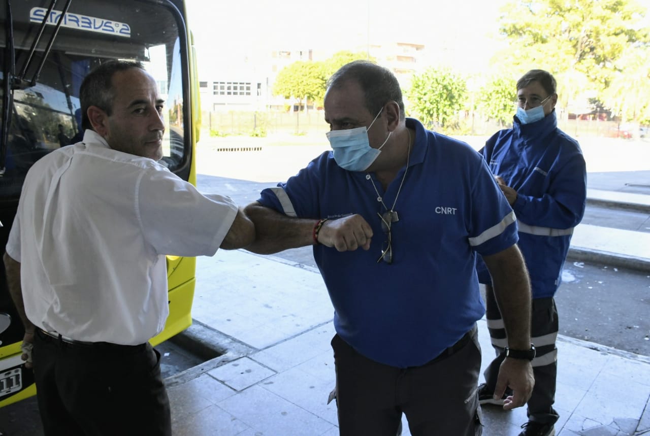 Codo a codo, saludo sanitario en la terminal de ómnibus.