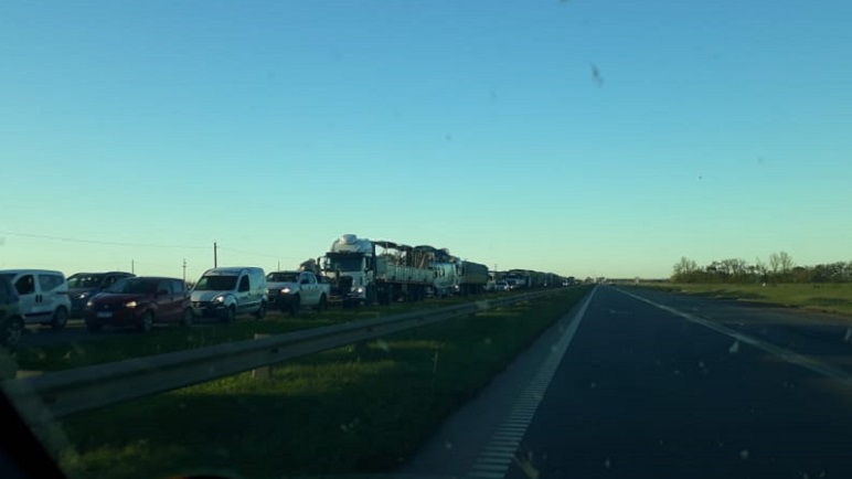 La fila de vehículos se extendía por detrás de la rotonda del cruce a Bigand.