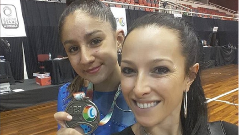 Agostina, junto a su entrenadora, exhibiendo su premio.