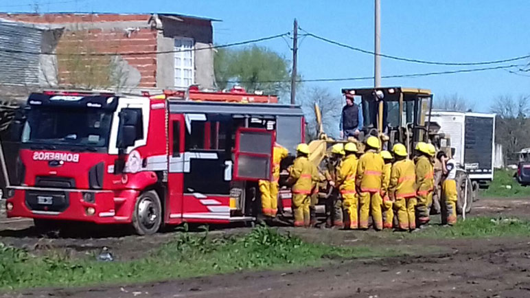 Los bomberos colaboran para sacar su propia autobomba.