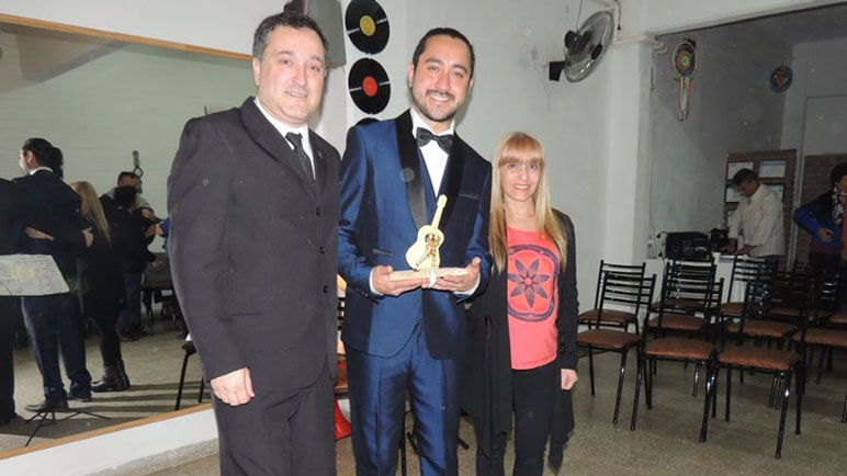 Lucho Rios exhibe con orgullo su premio. A su lado, Raúl Lanas y Andrea Póveda.