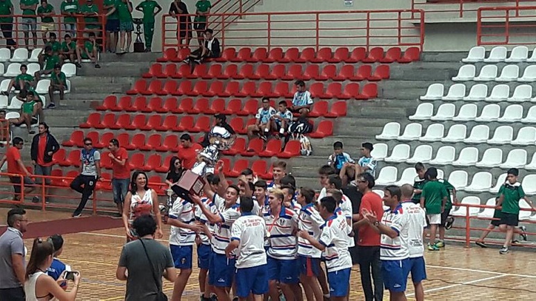 El plantel levanta el trofeo en ceremonia de clausura.