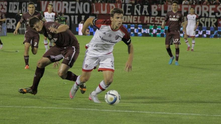 Boyé llevando el balón ante la marca del defensor granate.