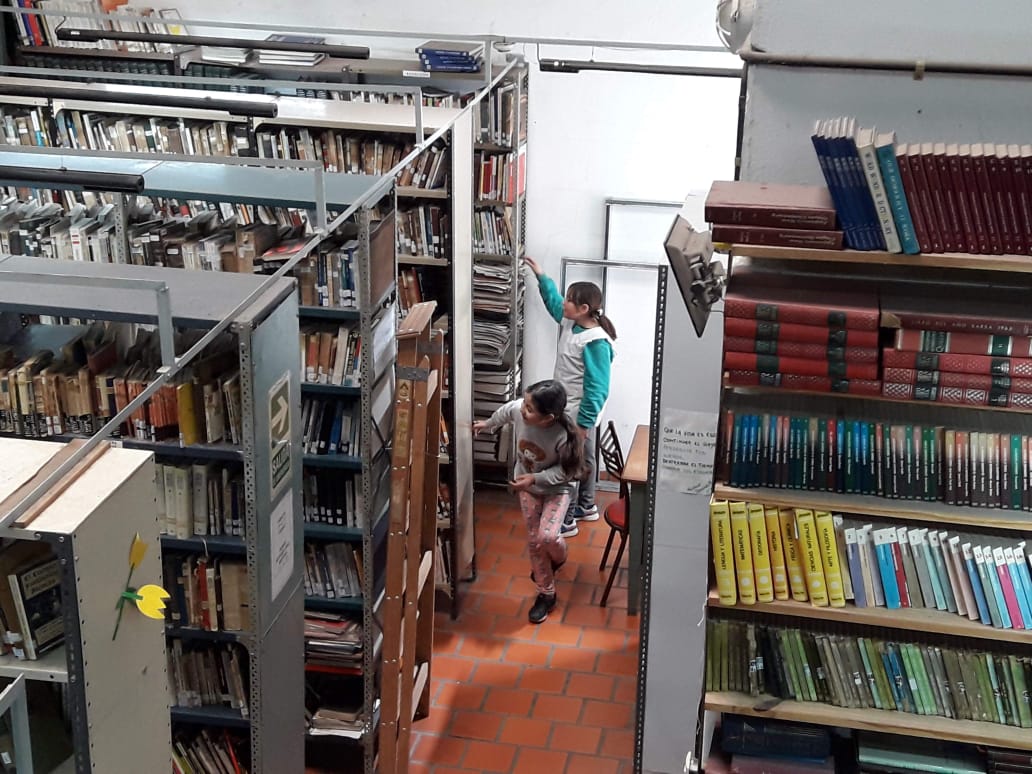 Niñas buscando libros en la biblioteca Alberdi, antes de la pandemia.