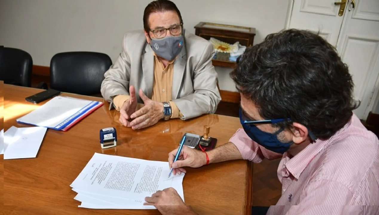 El Intendente Golosetti firma en presencia del senador departamental.