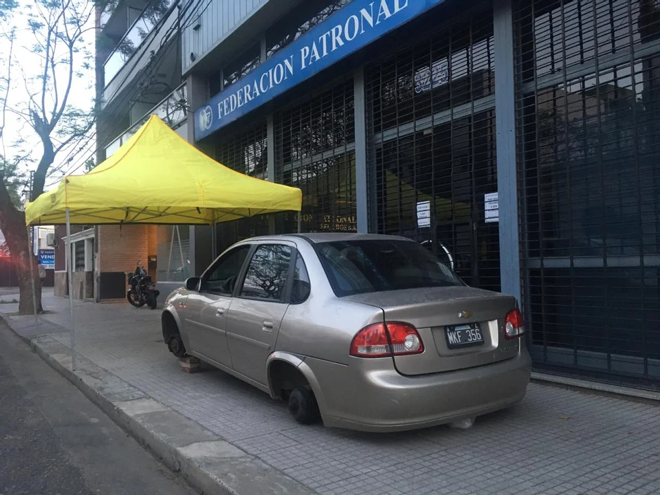 El auto en la vereda como prueba del reclamo, y el gazebo del cliente que se siente engañado por su aseguradora. (RosarioPlus)