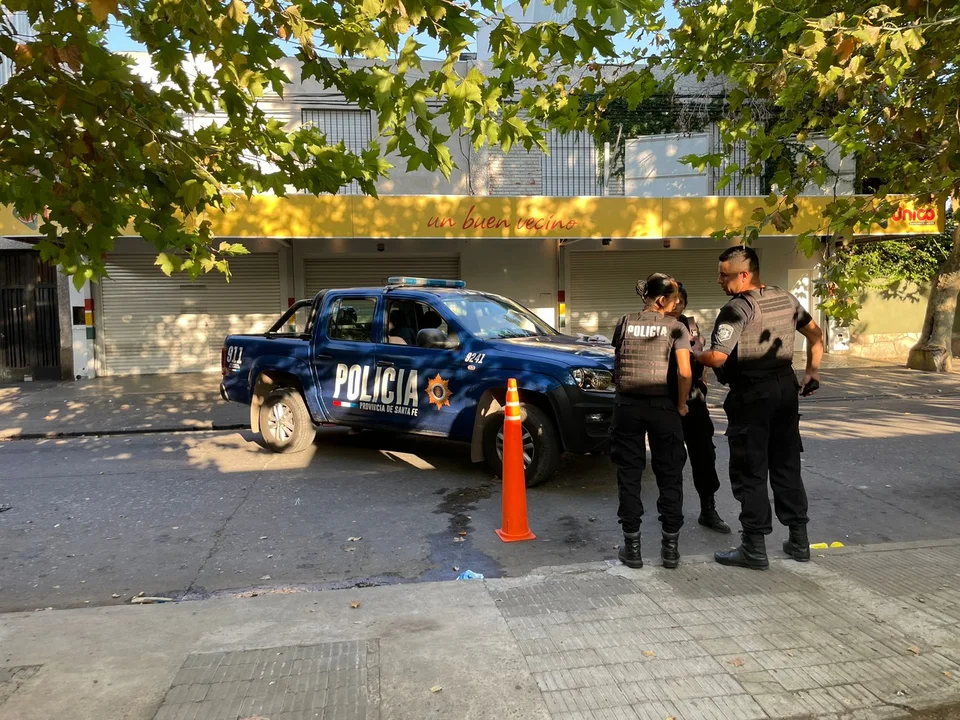 Policías hacen el peritaje de rigor en el supermercado baleado. (foto Sofía Levin / radio Sí 98.9)