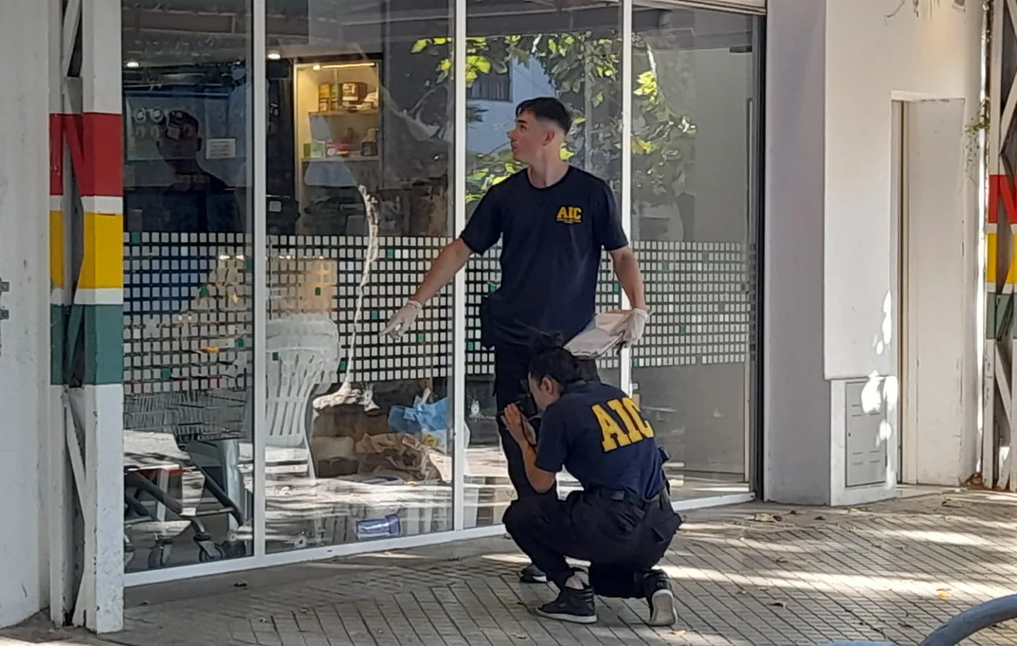 Policías hacen el peritaje de rigor en el supermercado baleado. (foto Sofía Levin / radio Sí 98.9)